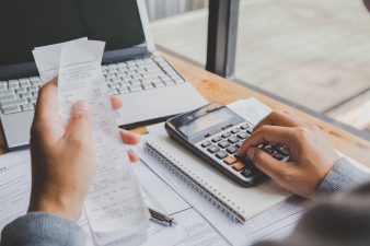 young-man-using-calculator-and-calculate-bills-in-home-office